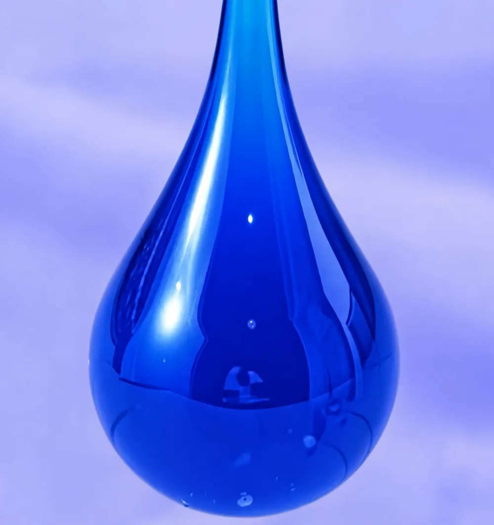 Gota de colorante azul intenso sobre fondo lavanda